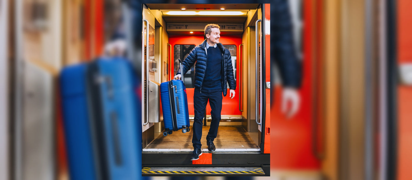 Hero Peter walking out of train with Revolution suitcase