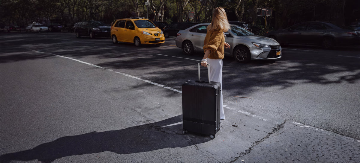 Kvinde med en sort Montblanc MY4810 kuffert på en gade i New York